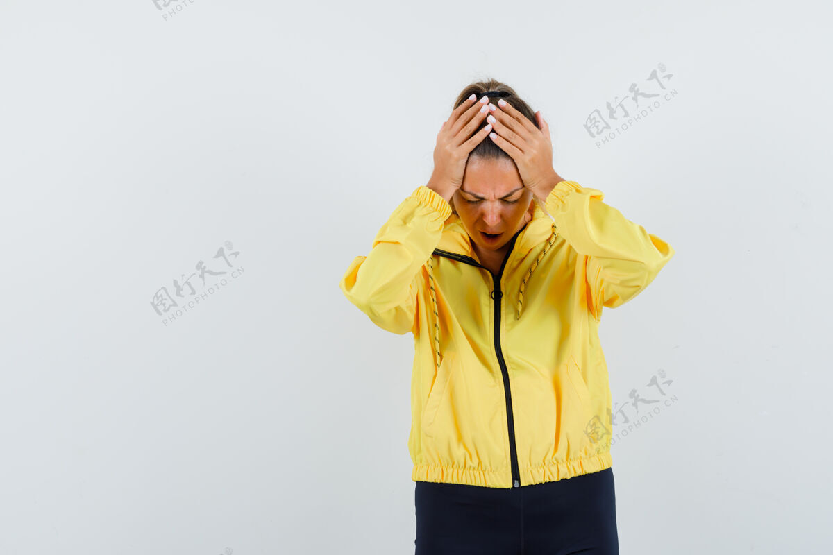 人穿着黄色棒球服和黑色裤子的年轻女子双手放在头上 看上去精疲力尽护理健康人