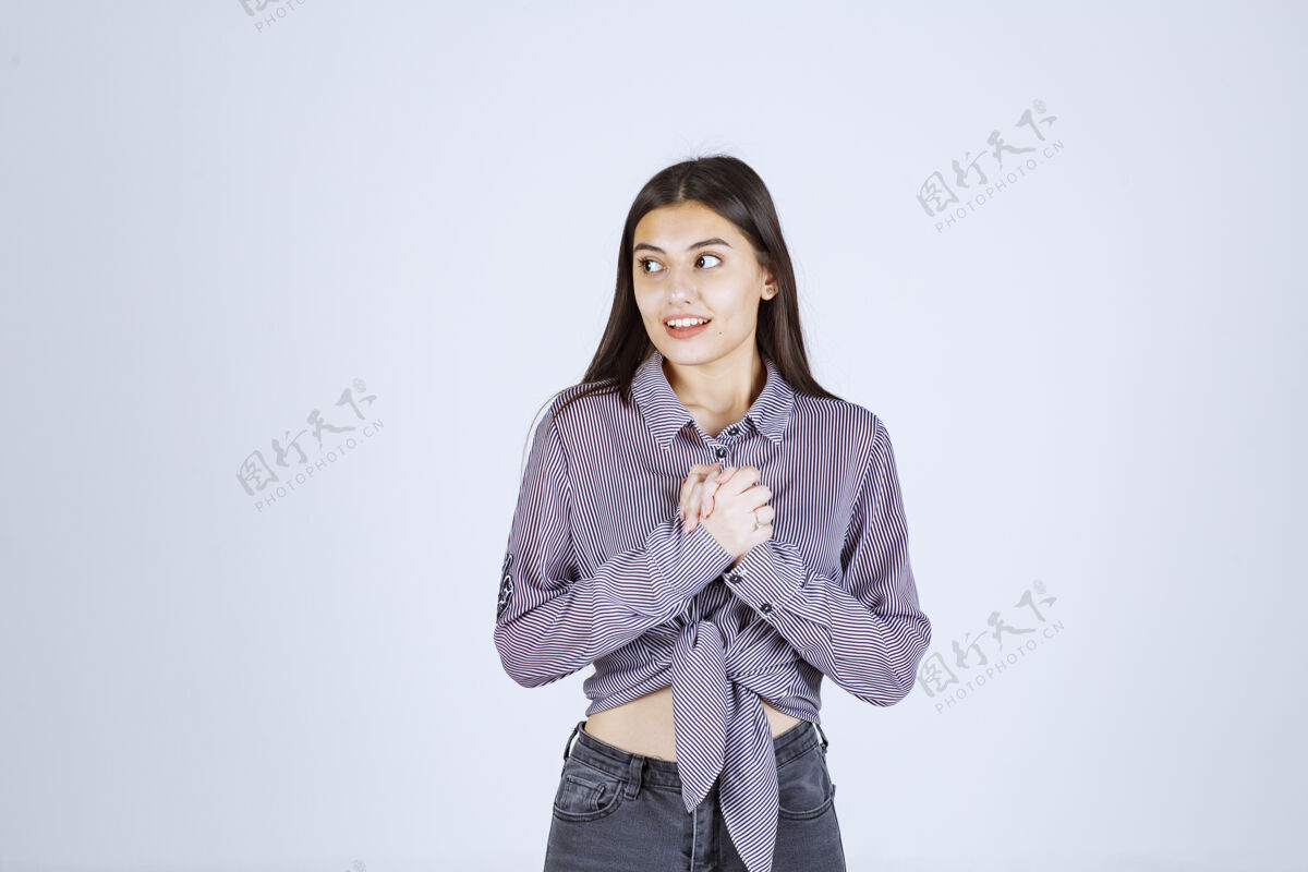 休闲穿紫色衬衫的女孩看起来害羞而矜持工人女人成人
