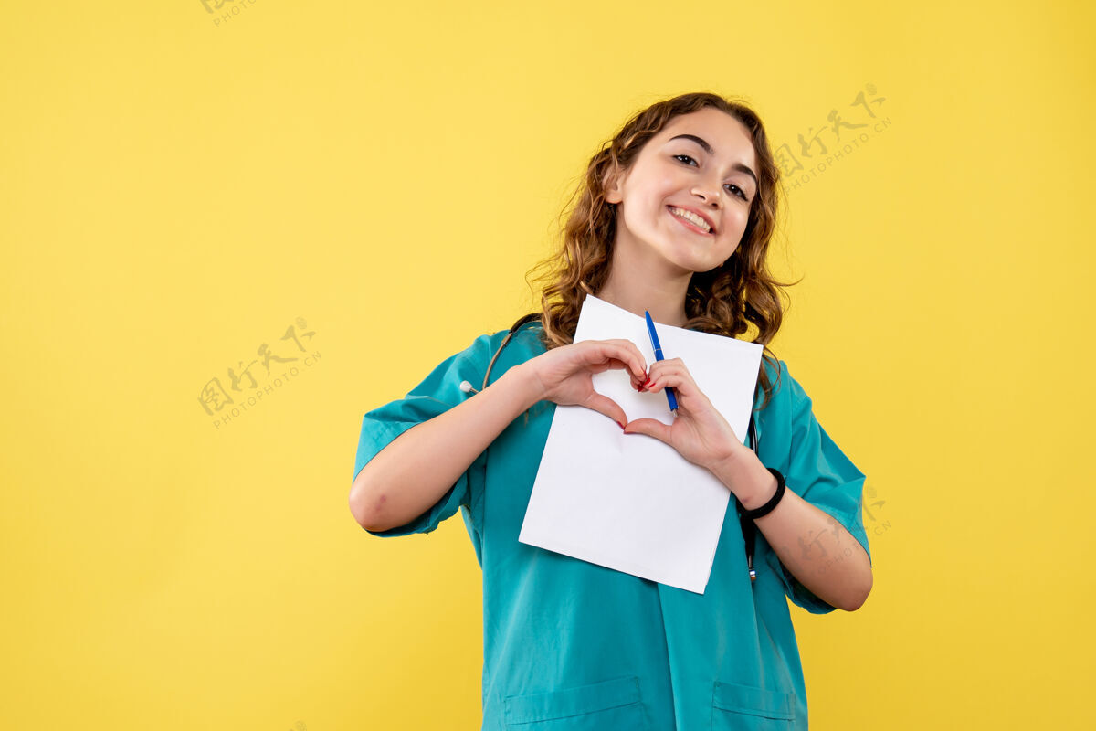 可爱正面图女医生穿着医用衬衫拿着黄色办公桌制服分析covid-19健康情绪大流行病毒医疗文件一张纸