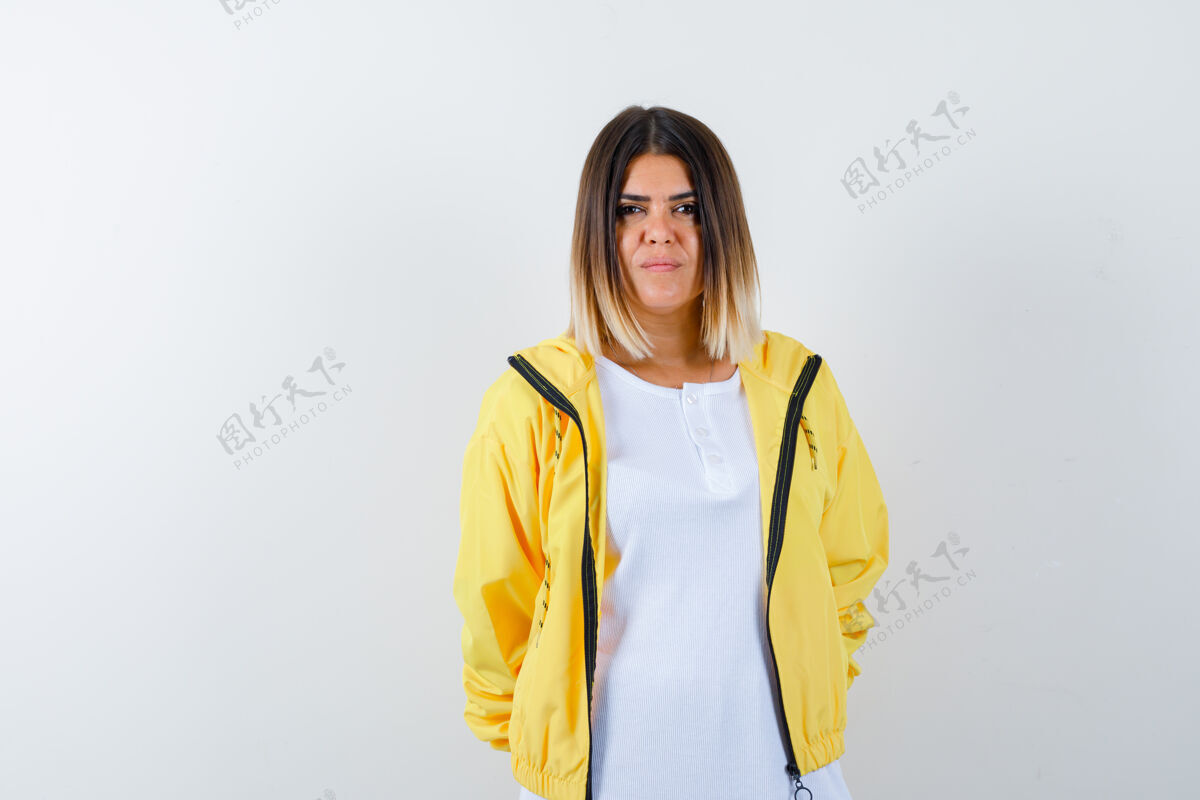 皮肤年轻女孩笔直地站着 穿着白色t恤 黄色夹克 严肃地站在镜头前夹克年轻相机