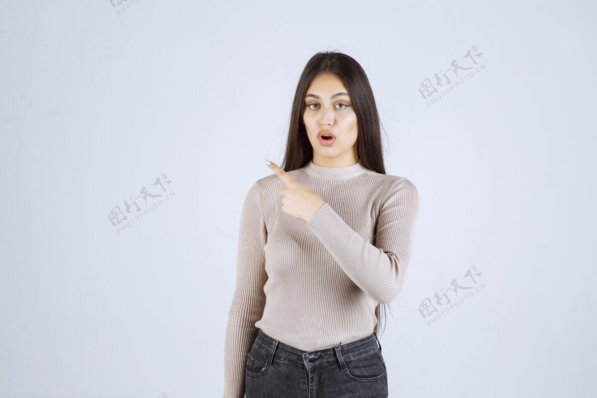 成人穿灰色毛衣的女孩展示左边的东西人类方向服装