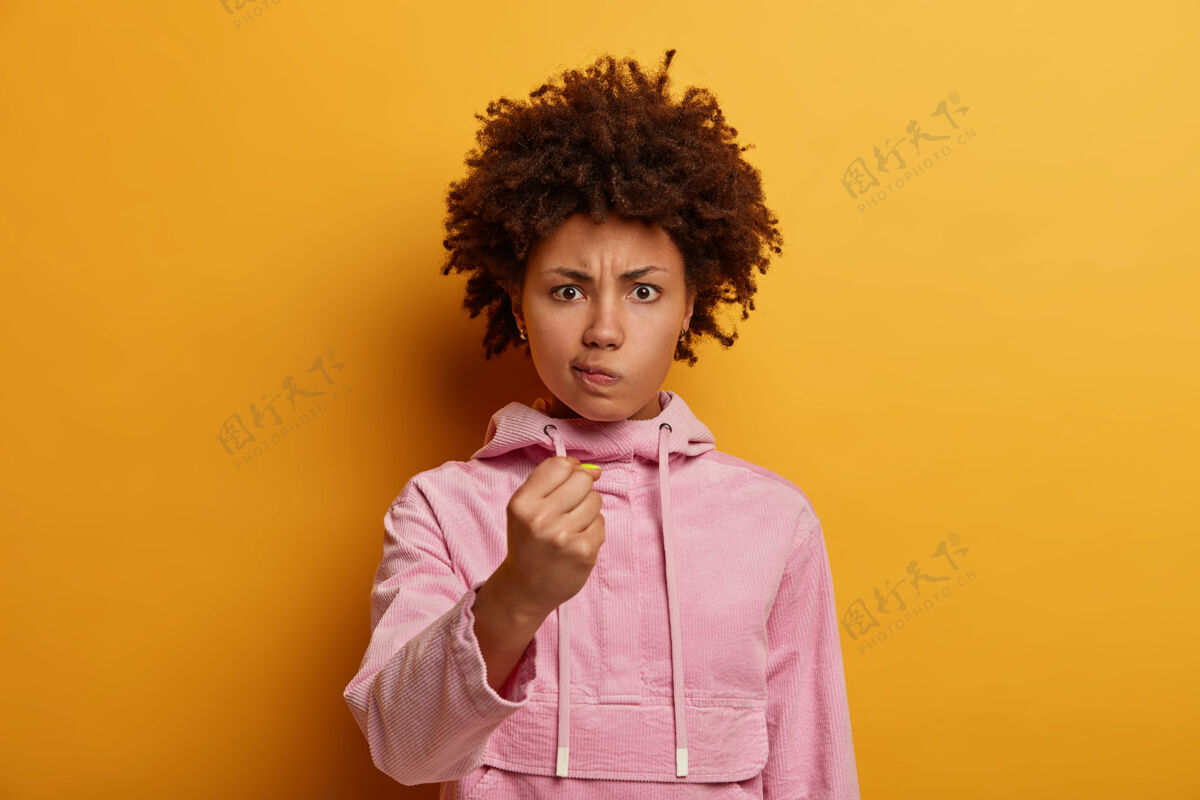 女人表情严肃不满的非洲发型女子握拳怒视不安人类连帽衫