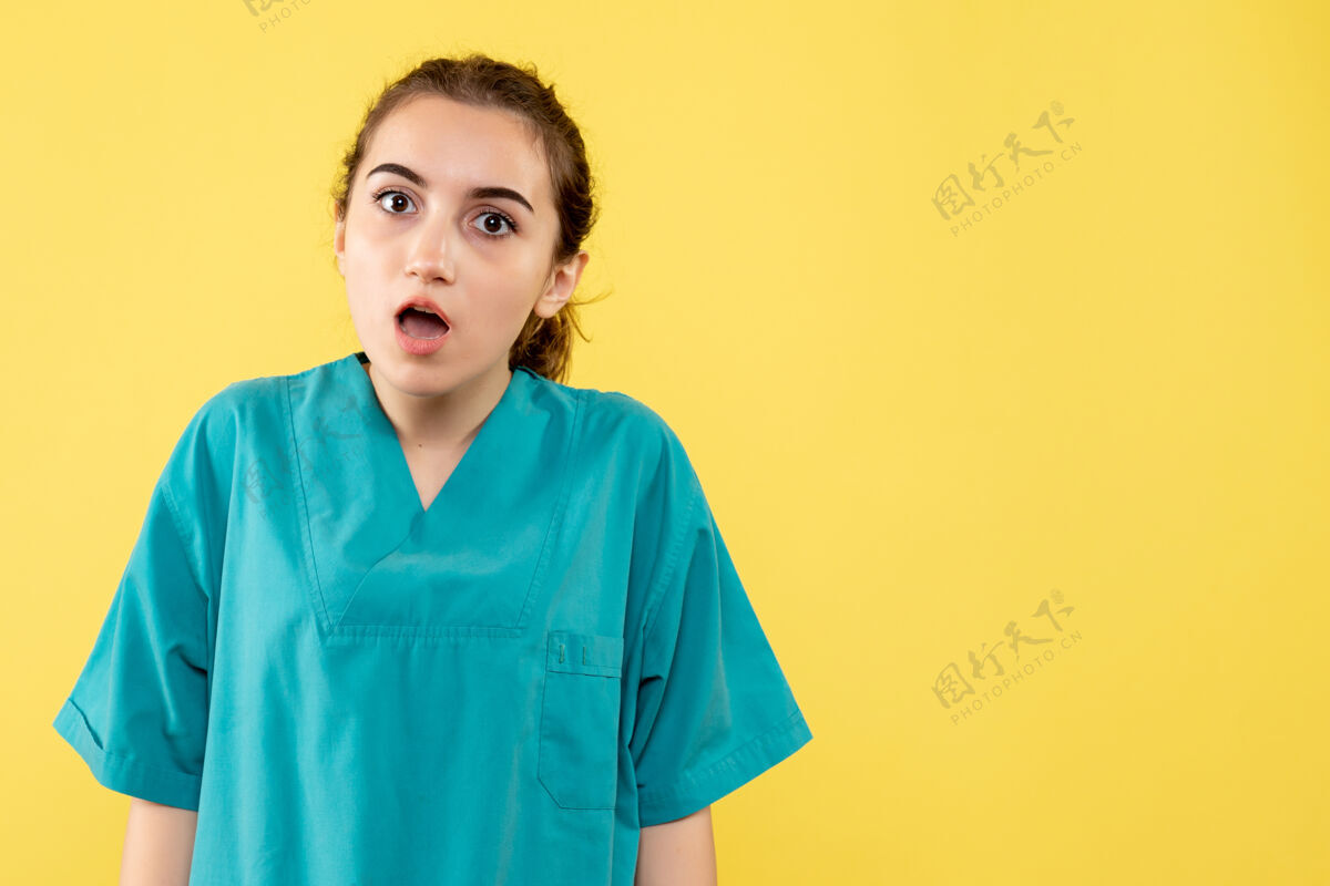 人黄色墙壁上穿着医疗服 脸上露出惊讶表情的女医生的正视图医院微笑惊喜