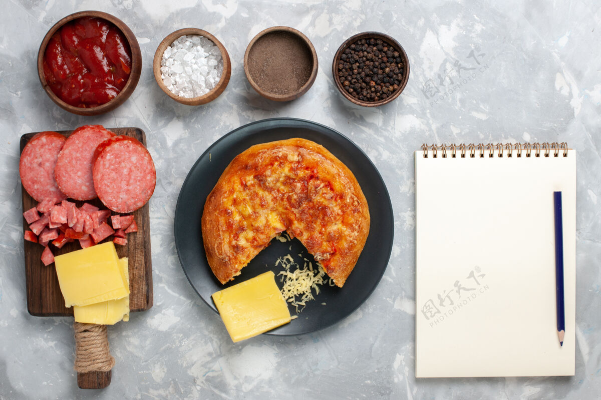 烹饪白色书桌上有不同调味品的顶视图奶酪披萨丰富多彩美食配料