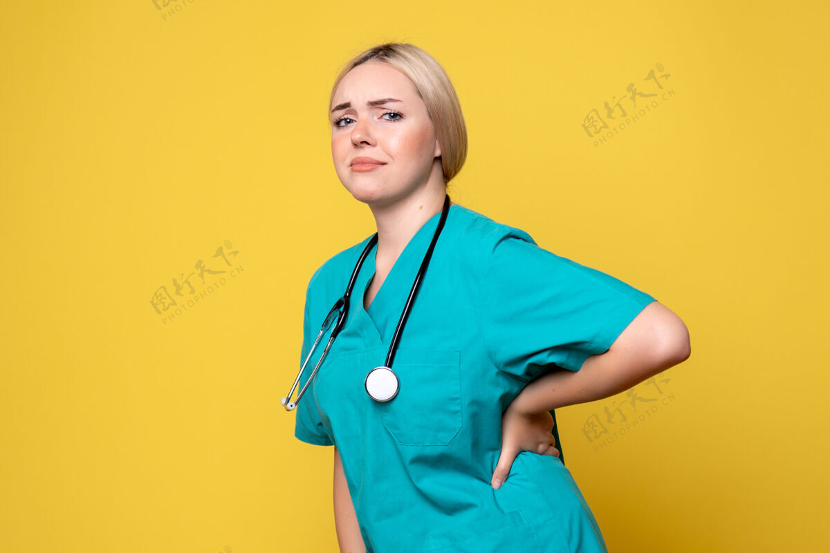 护士黄色墙上穿着带听诊器的医用衬衫的女医生的正视图医疗器械听诊器医疗
