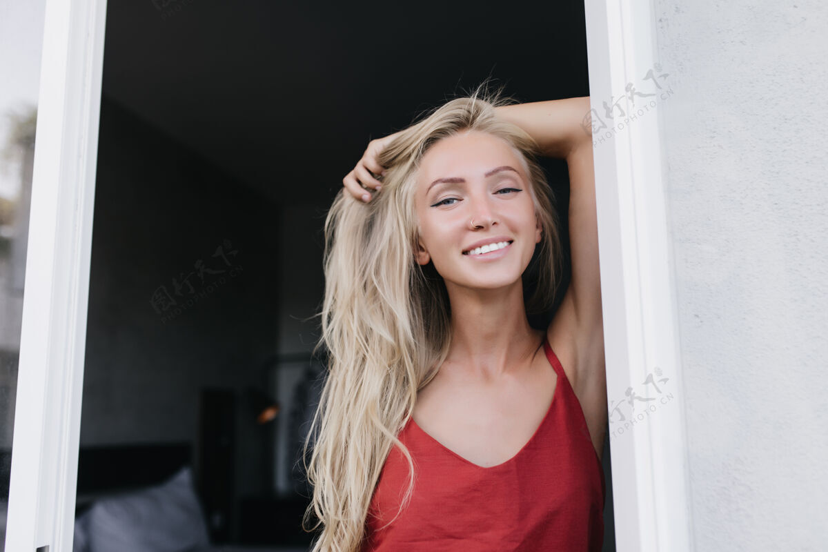 肖像欣喜若狂的高加索女模特清晨摆出真诚的微笑浪漫的漂亮女人穿着红色睡衣玩得开心华丽模特女士