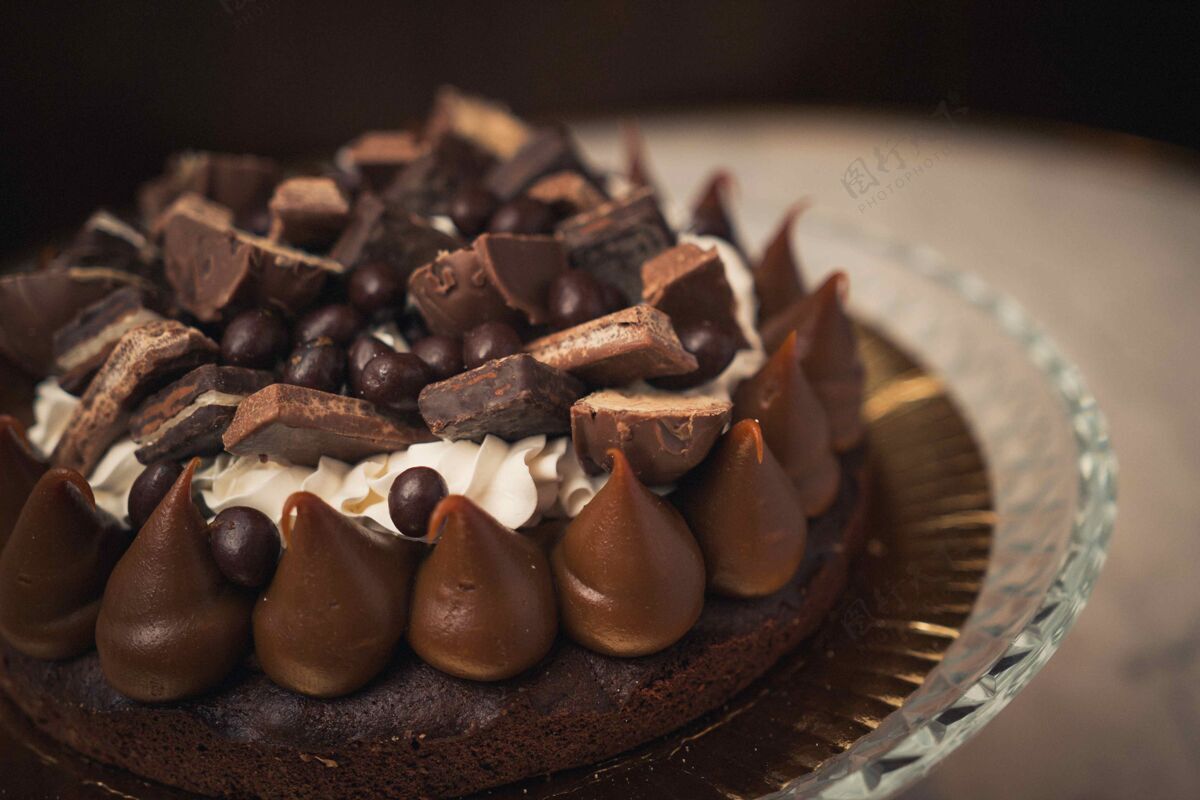 奶油特写镜头美味的巧克力蛋糕在一个玻璃盘上的一张桌子上堆叠霜糕点