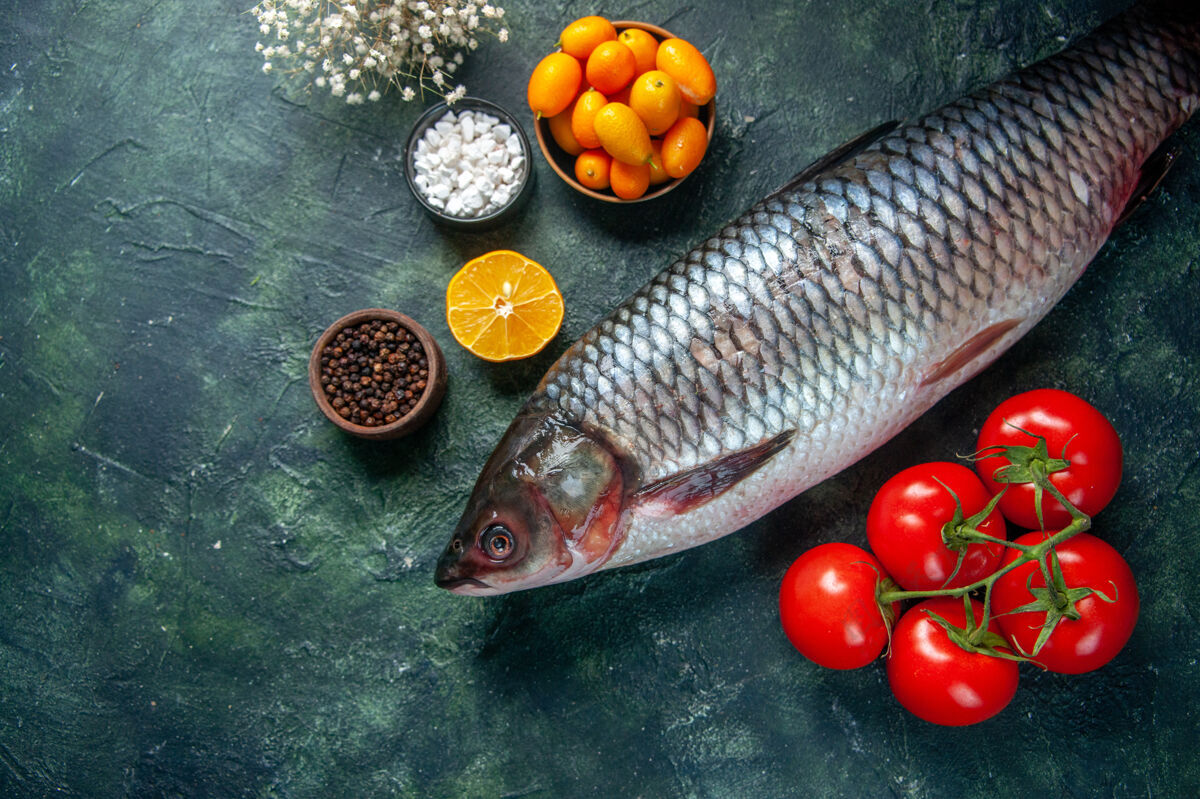 水果顶视图新鲜生鱼与红色西红柿在黑暗的背景红色深色饮食