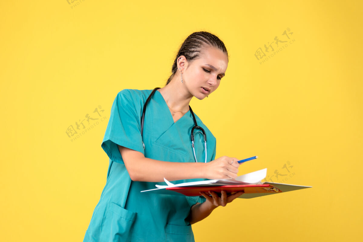 医院黄色墙壁上穿着不同分析的医疗服的女医生的正面图临床西装女医生