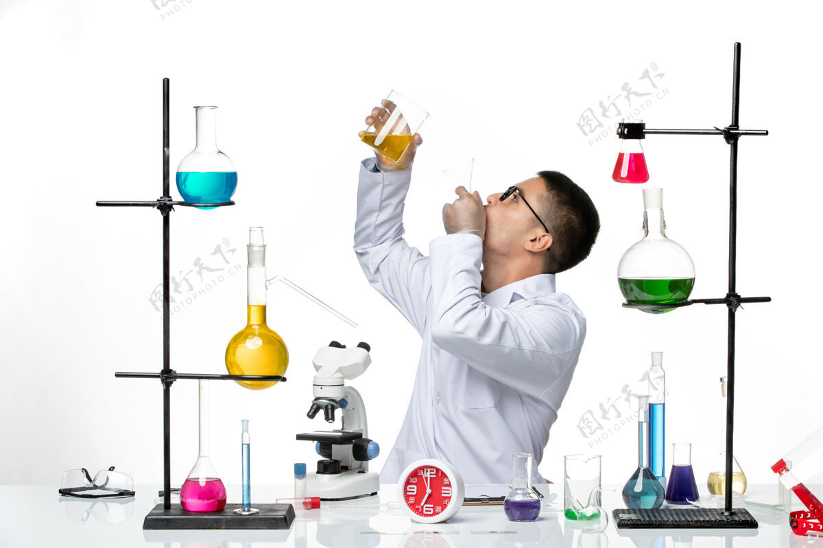 医生正面图：穿着白色医疗服的男性化学家正在白色办公桌上处理科学病毒-实验室大流行病毒的解决方案科学桌子实验室