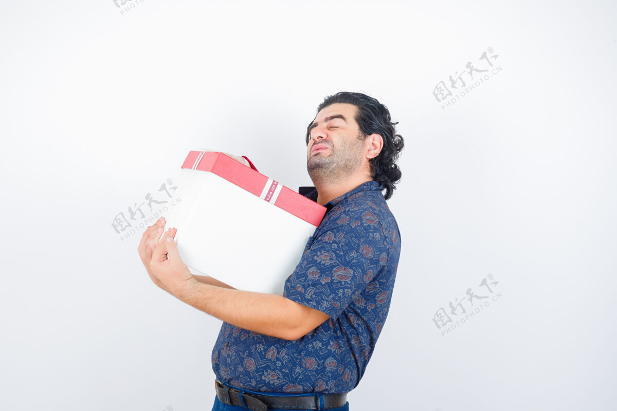 健康成熟的男人拿着礼盒在衬衫上 看起来很累 前视图老年抑郁房间
