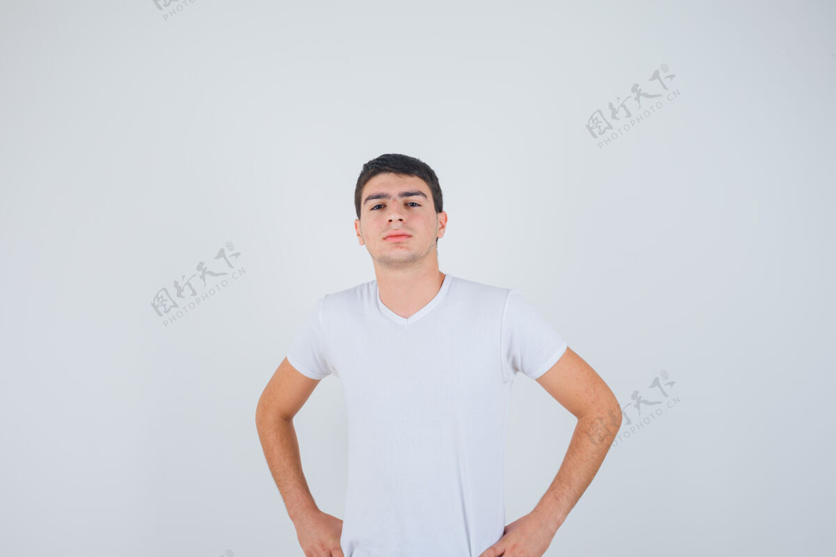 自信年轻男性穿着t恤 双手放在腰上摆姿势 看起来很自信 正面照姿势腰时尚