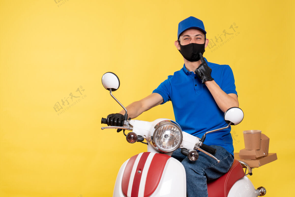服务正面图身穿蓝色制服 戴着黄色自行车面罩的男性快递员柯维德-大流行性病毒快递工作人病毒工作