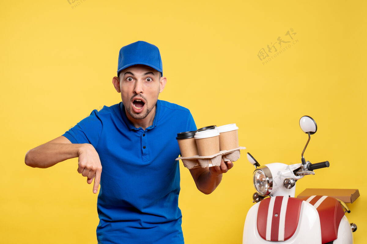 高尔夫球手正面图：男快递员拿着黄色工作服上的咖啡 工作服 自行车工工作工作制服