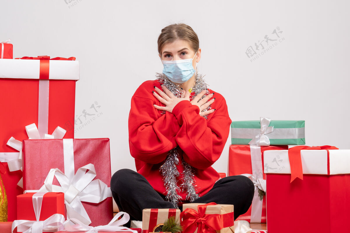 年份正面图：戴着面具坐着的年轻女性礼物病毒坐着