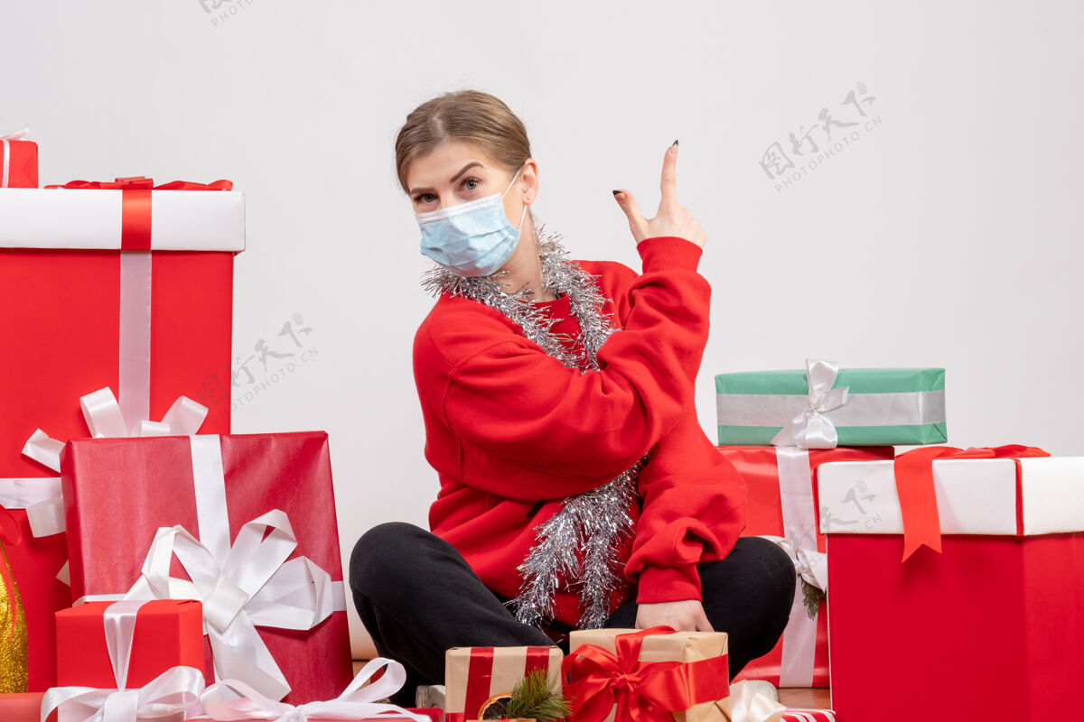 情感正面图年轻女性戴着面具围坐在圣诞礼物旁礼物病毒微笑