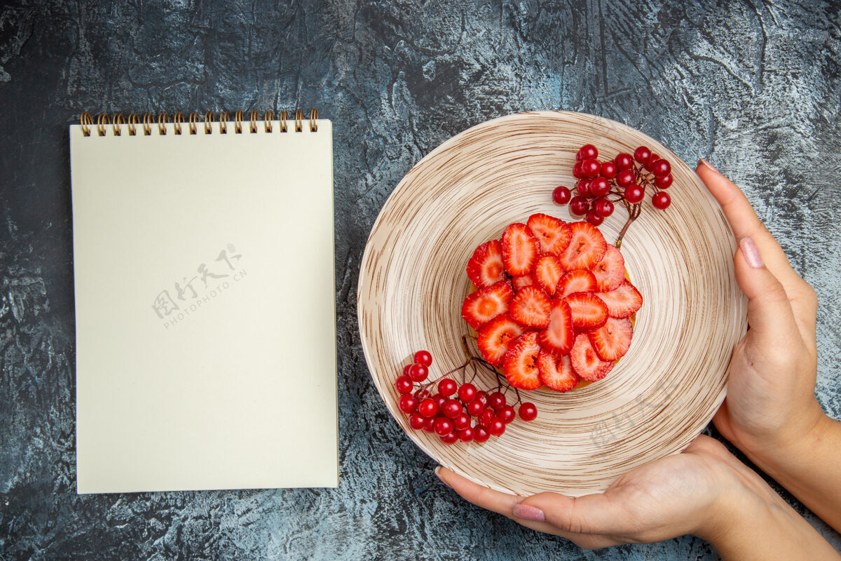 碗顶视图美味的草莓蛋糕与红色浆果在黑暗的背景饮食黑水果