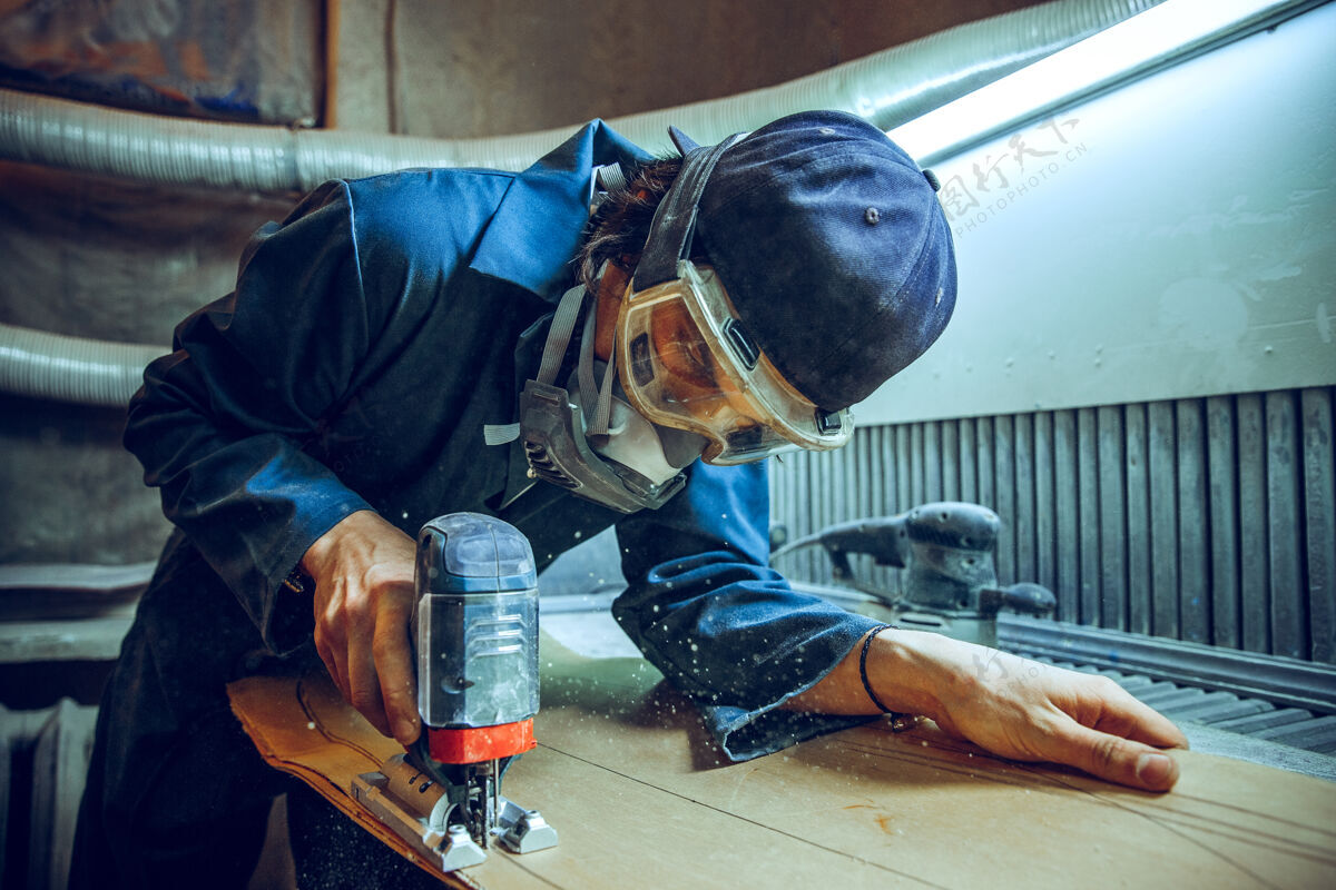 木材使用圆锯切割木板的木匠男工人或手持电动工具的手巧工人的施工详图专业电力车间