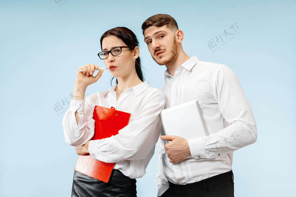 夫妻商业伙伴关系的概念在工作室蓝色背景下的年轻情感男女人类情感和伙伴关系的概念伙伴关系男性立场