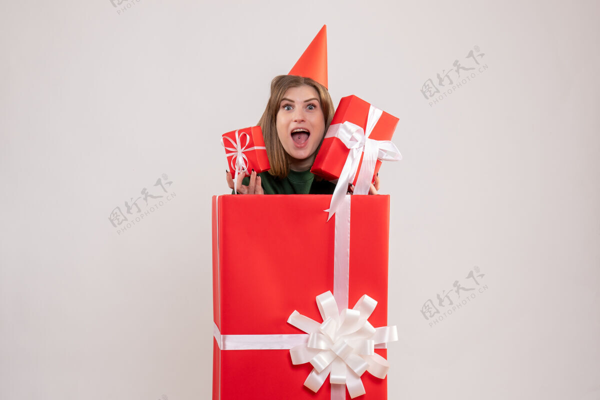 颜色正面图：红色盒子里的年轻女性 带着礼物盒子圣诞节礼物