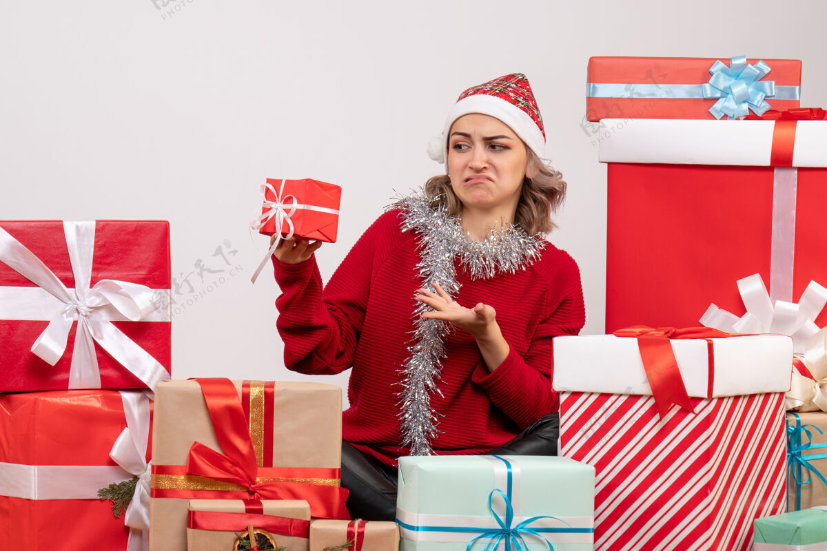 圣诞节正面图年轻女性围坐在圣诞礼物旁盒子庆祝人