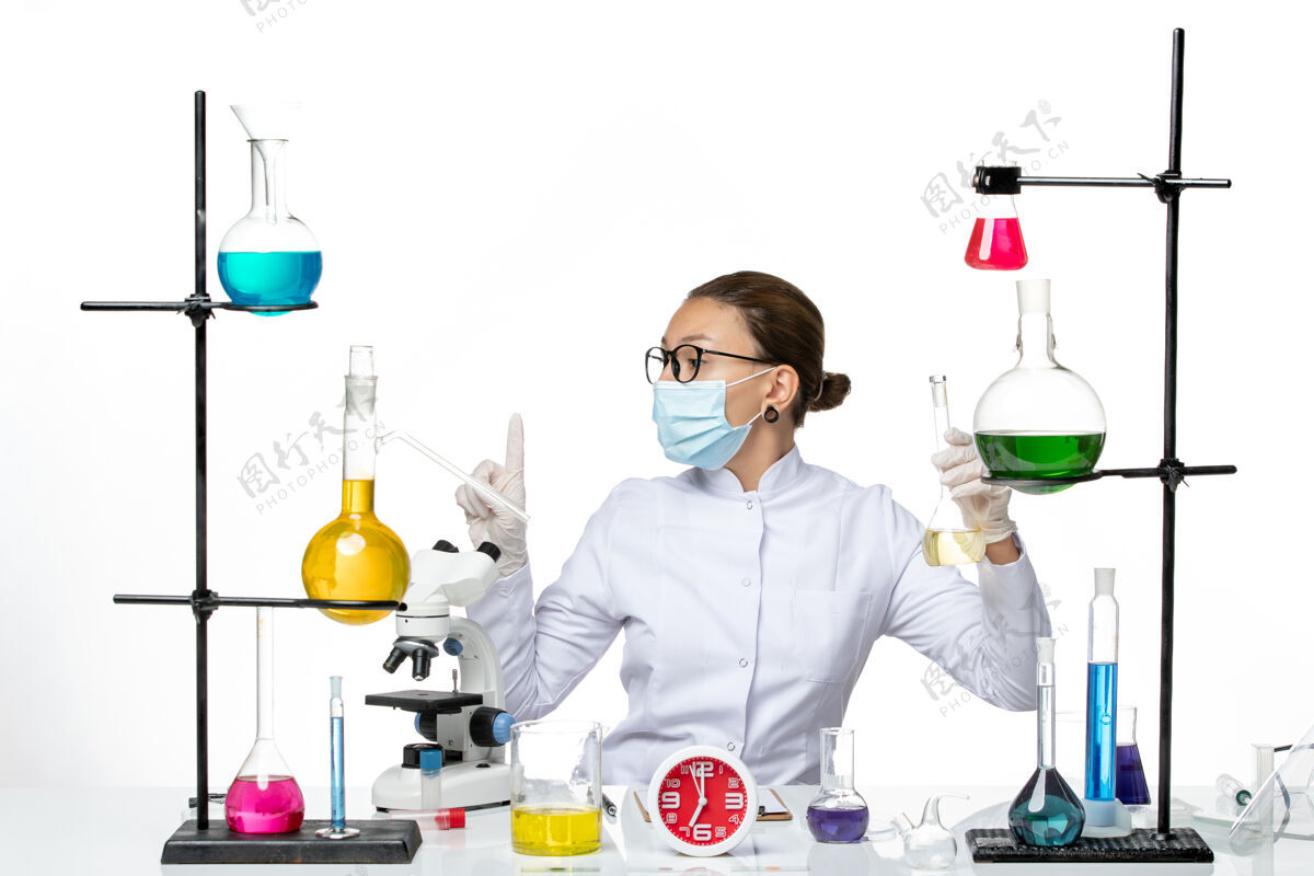 地板前视图：穿着白色医疗服的女药剂师 在白色地板上戴着口罩 药剂师实验室的病毒冠状病毒飞溅化学家药品专业人员