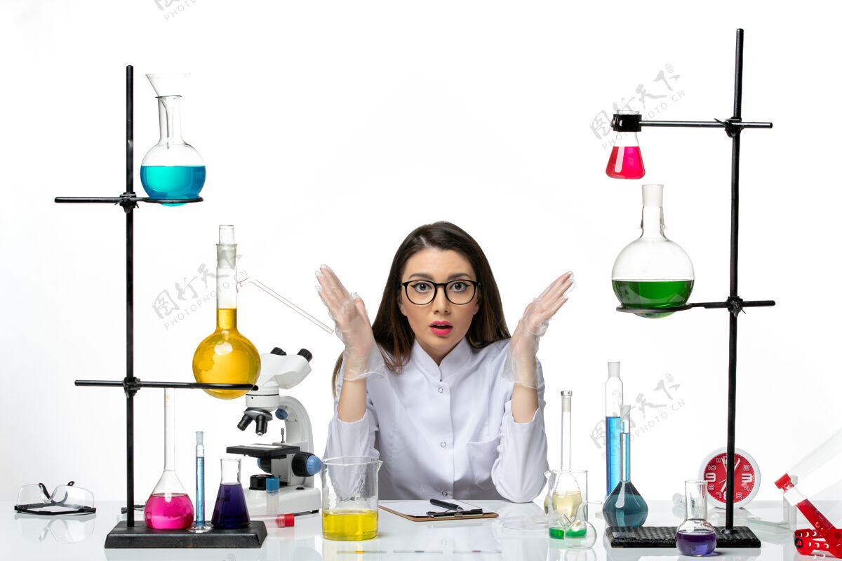 医疗正面图：身着医疗服的女化学家围坐在桌子旁 白色办公桌上摆着解决方案实验室病毒冠状病毒大流行科学烧杯大流行视图