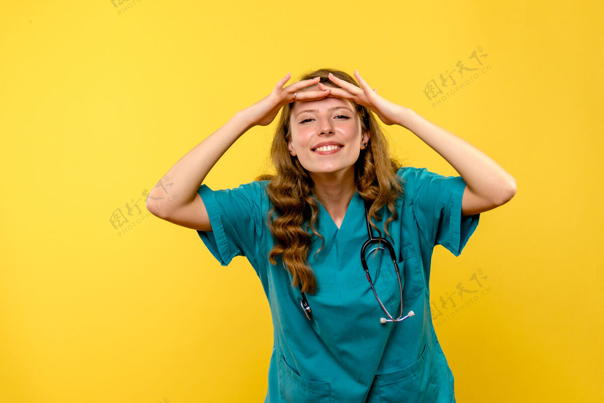 前面黄墙上女医生看远处的正面图医院女士制服