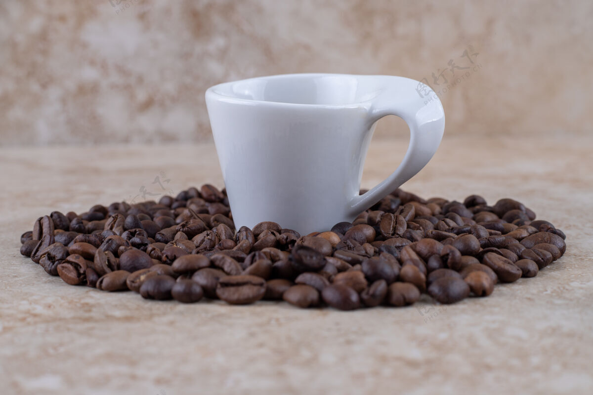 堆积整齐排列的咖啡豆堆围绕着一杯咖啡咖啡排列咖啡因