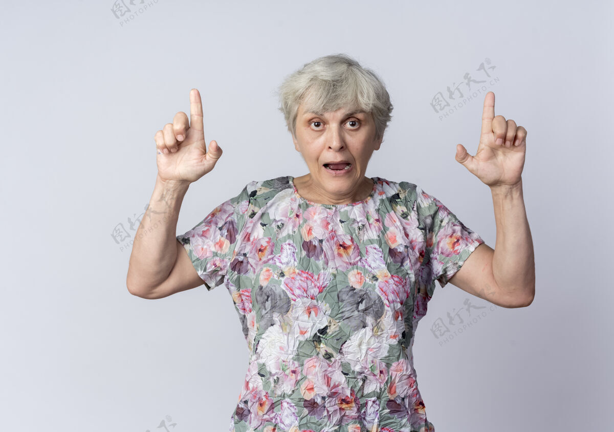 老人焦急的老妇人用两只手孤立地指着白墙上女人向上急