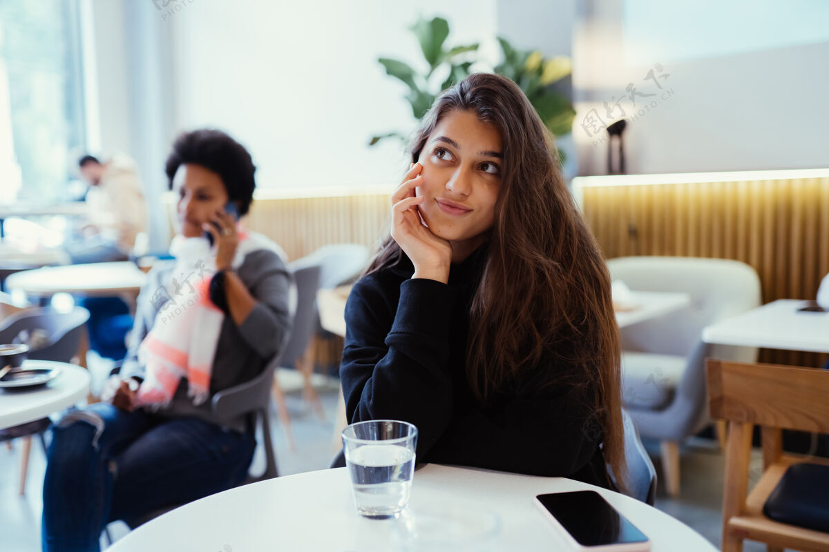 女人坐在咖啡馆里思考和仰望的女人的画像抬头坐着思考