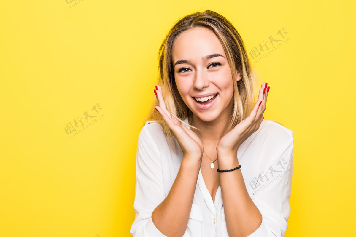 年轻兴奋尖叫的年轻女子孤立地站在黄色墙壁上的画面欢呼漂亮卷发