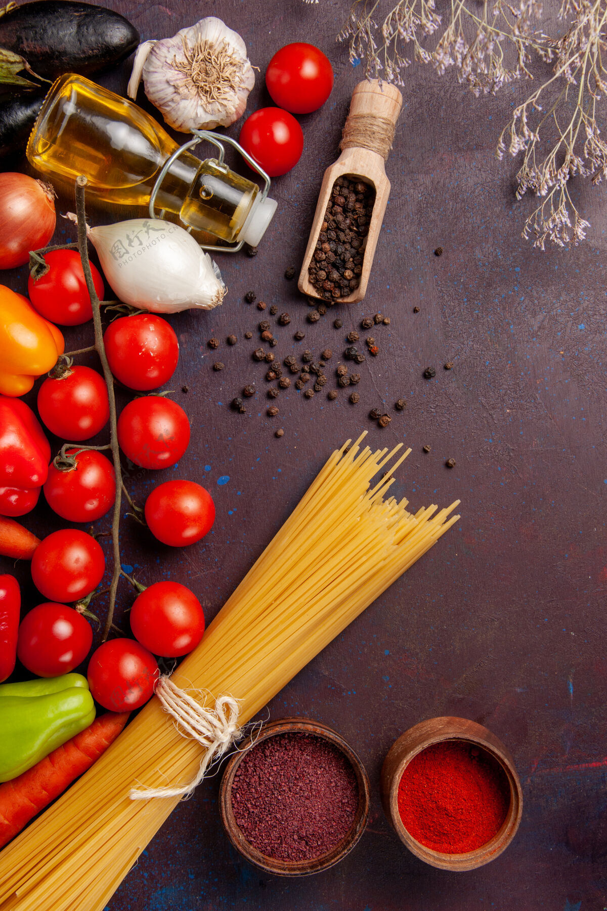 不同顶视图不同的新鲜蔬菜与意大利面食和调味品在黑暗的空间素食一餐顶级