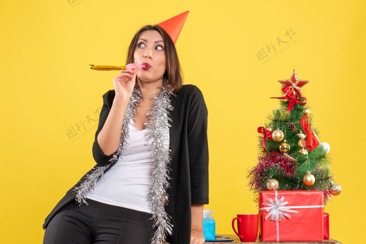 时尚圣诞节的心情与惊喜美丽的女士在黄色的办公室摆姿势拍照黄色美女脸