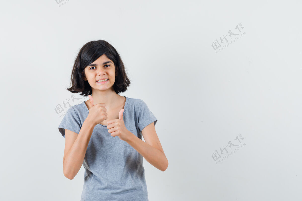 欢呼小女孩穿着t恤向上竖起大拇指 看上去很快乐正视图人脸微笑