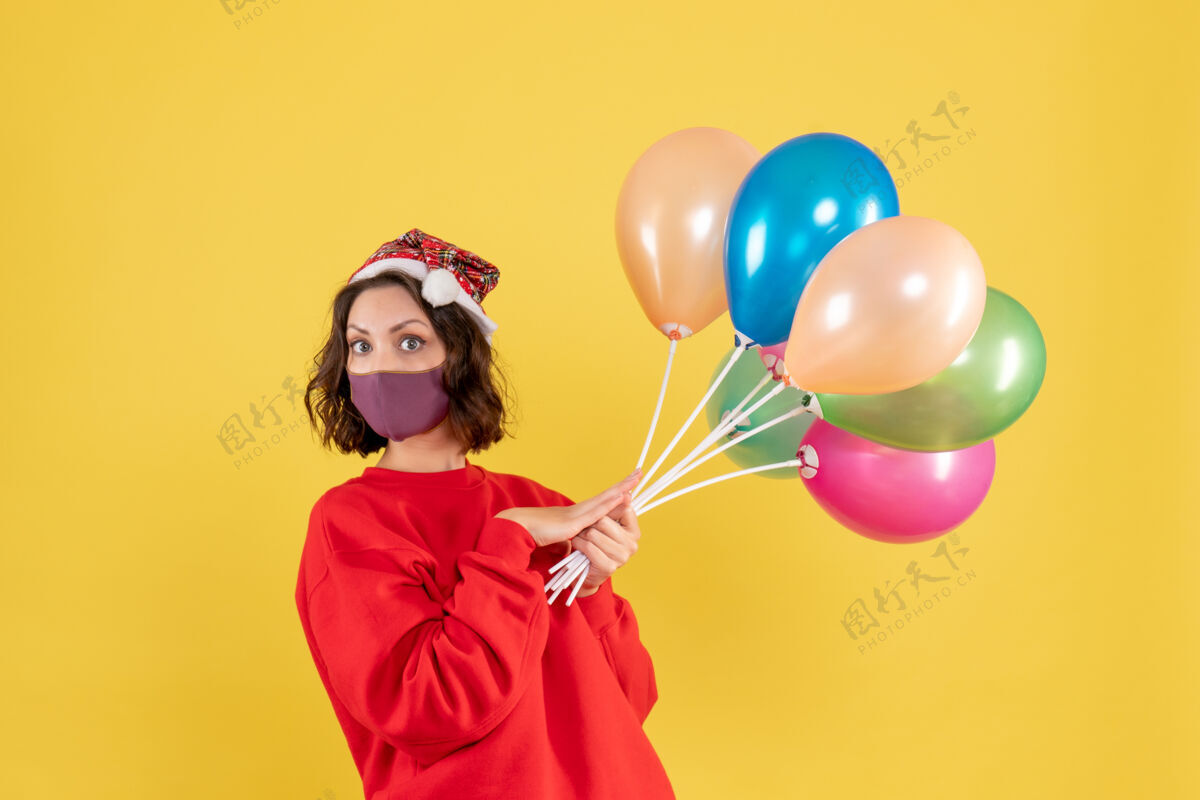 乐趣正面图年轻女性拿着气球 戴着黄色的无菌面具颜色视图聚会