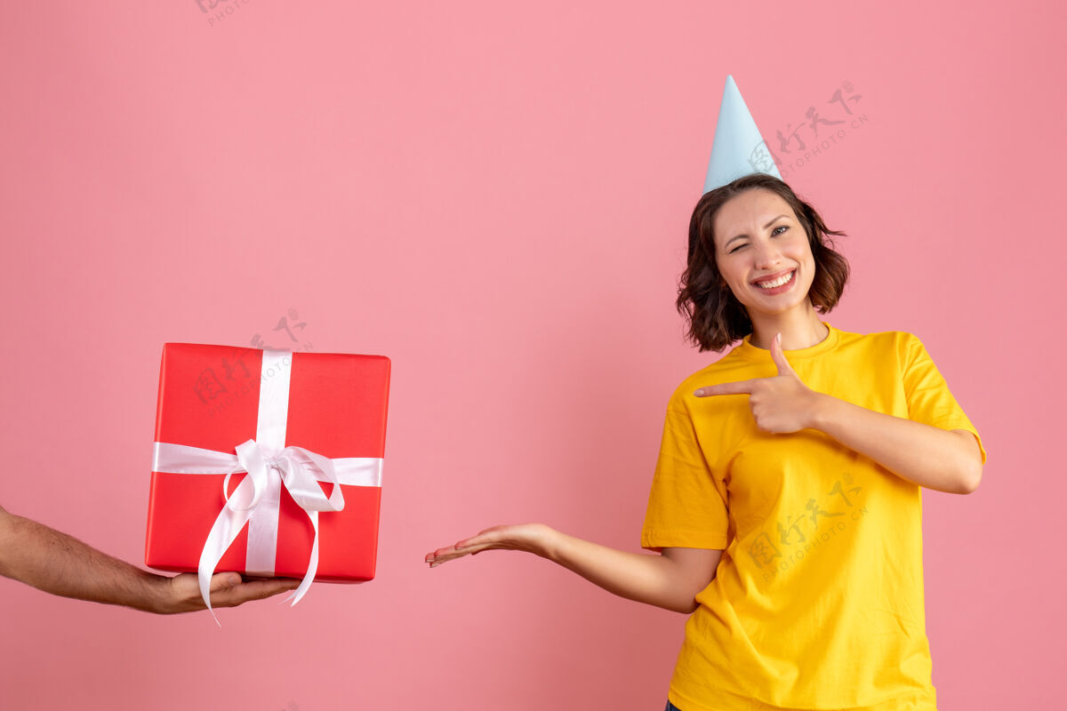 礼物正面图：年轻的女性在接受来自男性的粉色礼物快乐圣诞节女人
