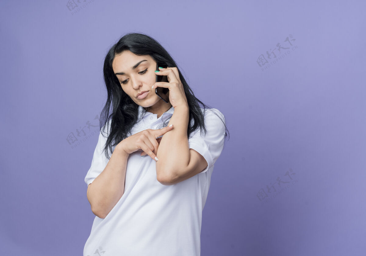 紫色自信的年轻黑发白种人女孩在电话里说话 看着紫色的墙上孤零零的一个人自信女人黑发