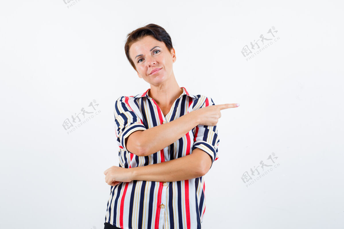 商务穿着条纹衬衫的成熟女人用食指指向右边 看起来很自信 正面视图年龄成人条纹