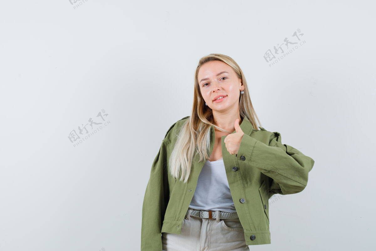 女士穿着夹克的年轻女士 单身汉竖起大拇指 愉快地看着 正前方的景色健康年轻夹克
