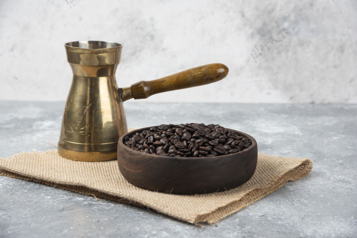 香味一个木制的碗 上面放着深烤咖啡豆和咖啡机 放在大理石表面上咖啡因美食农作物