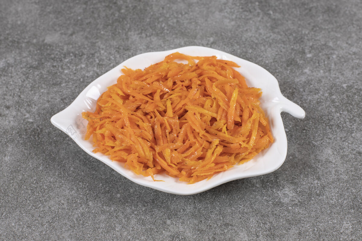 容器切碎的胡萝卜泡菜在盘子上的特写照片配料有机美味