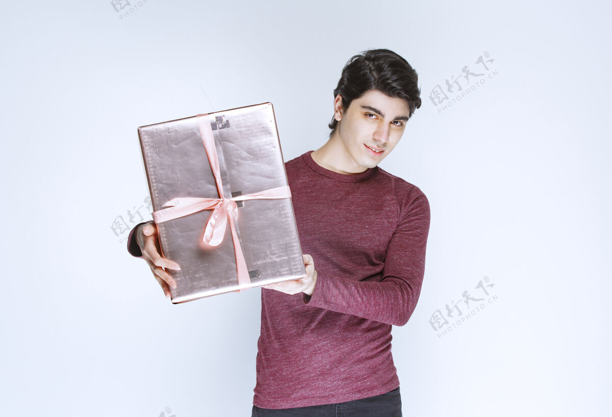 休闲一个男人拿着一个粉红色的礼盒 把它送给别人男朋友人年轻人