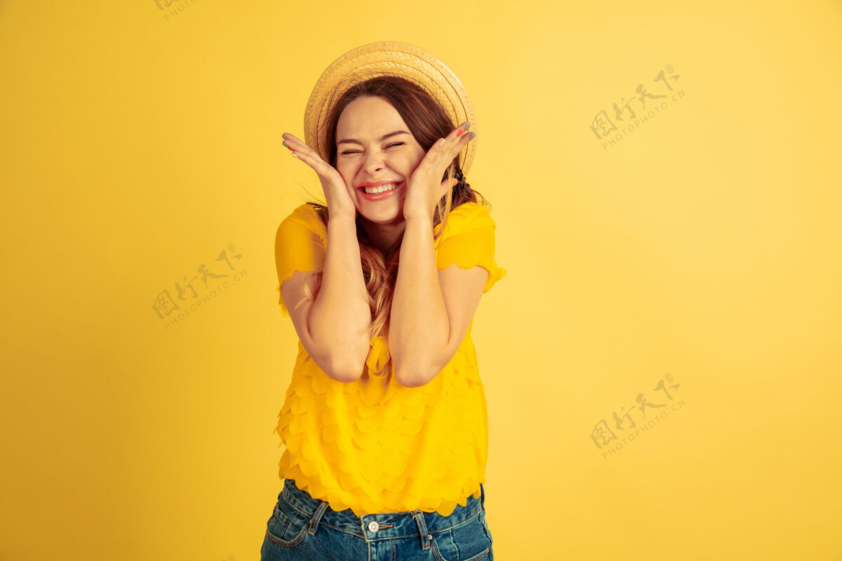 表情惊讶 震惊 可爱黄色工作室背景上的白种女人肖像戴帽子的漂亮女模特人类情感的概念 面部表情 销售 广告夏季 旅游 度假表达行政手