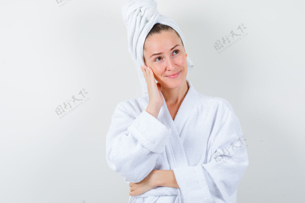 前面年轻的女士面颊靠在手上 穿着白色浴衣 毛巾 神情平和 俯瞰前方年轻干净模特