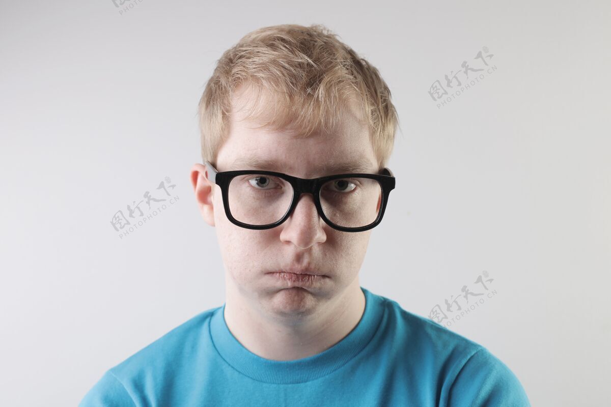 人特写镜头中 一位身穿蓝色t恤 戴着眼镜的白人男性做着滑稽的面部动作眼镜肖像眼睛