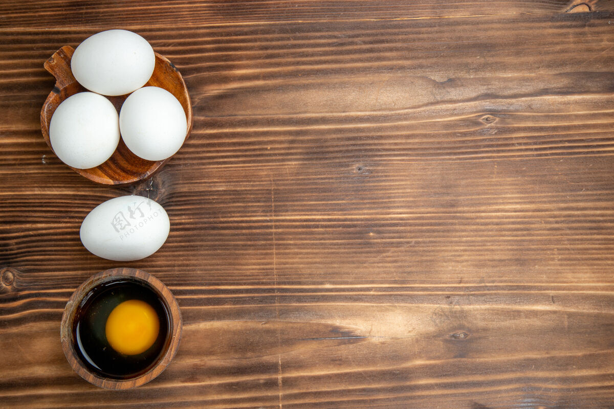 鸡蛋俯瞰棕色木质背景上的整个生鸡蛋早餐食物木质鸡蛋背景景观生的