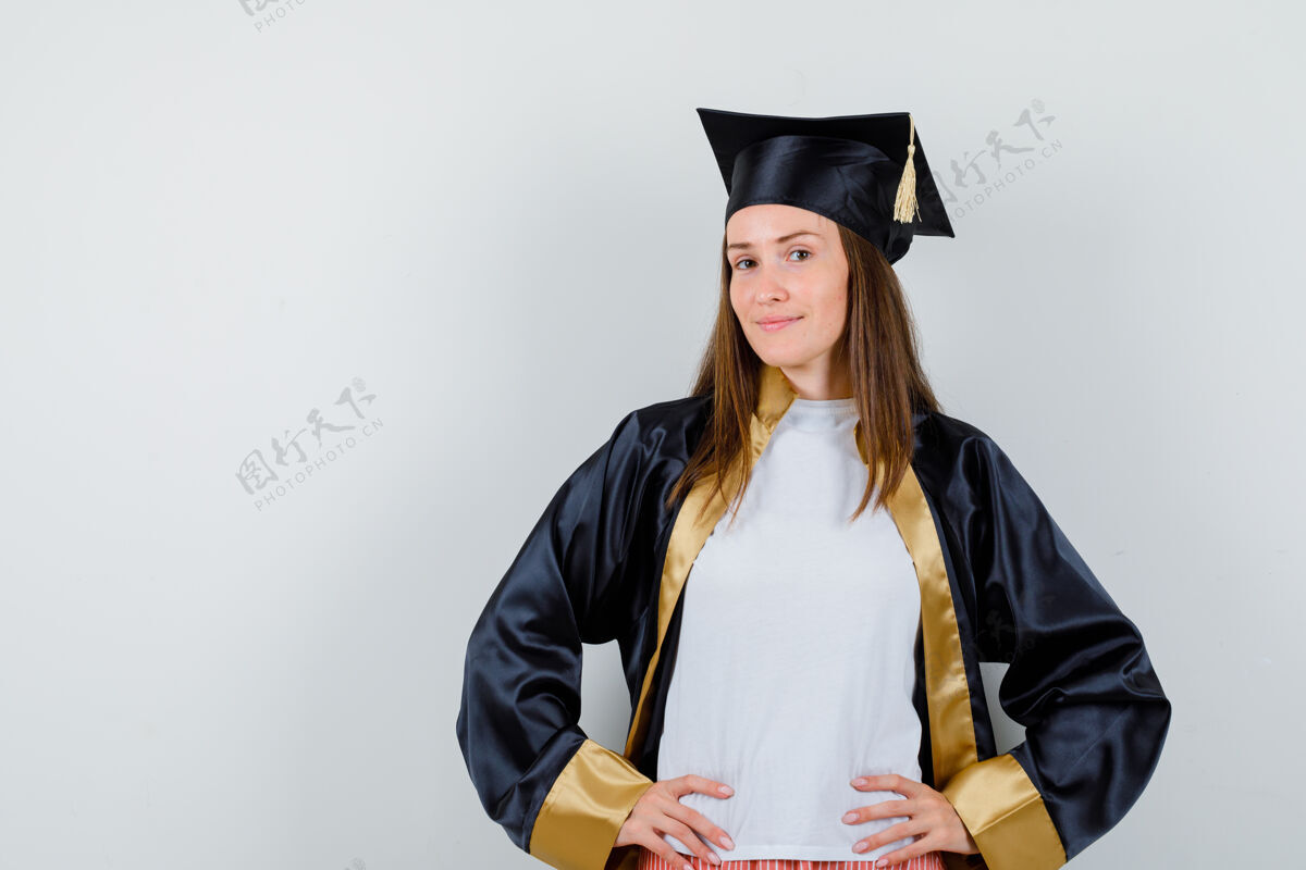 Cap女毕业生穿着学院服 双手放在腰上 看起来很自豪正面图学位保持大学