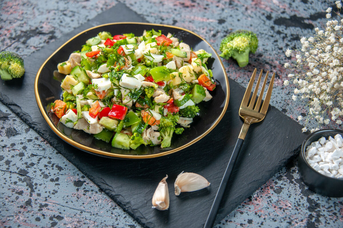 沙拉前视图蔬菜沙拉包括黄瓜奶酪和西红柿在黑暗的背景板内食物蔬菜一餐