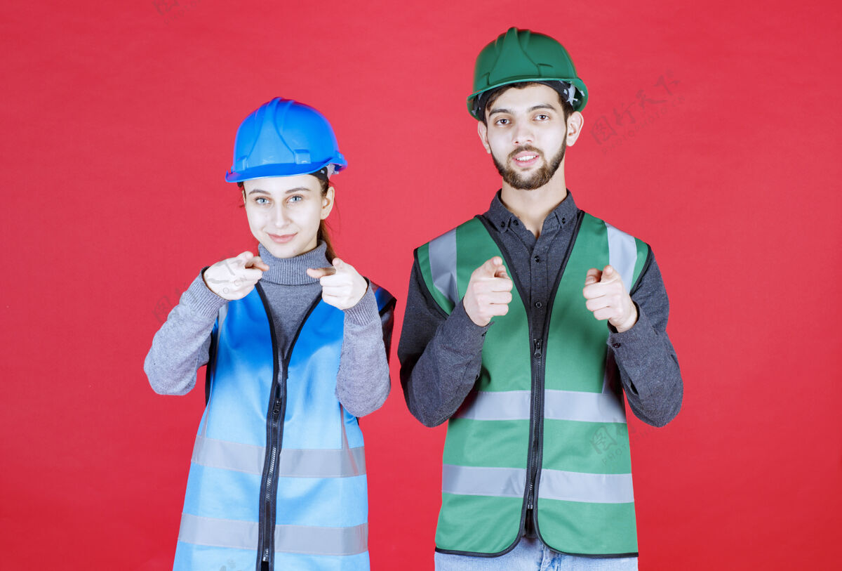 展示男女工程师戴着头盔和装备注意前方的人人装备制服